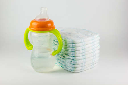 Baby diapers and bottle on a white backgroundの写真素材