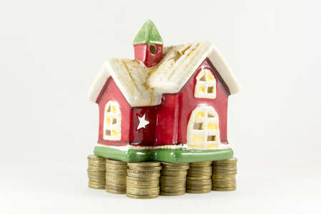 House stands on coins on a white background
