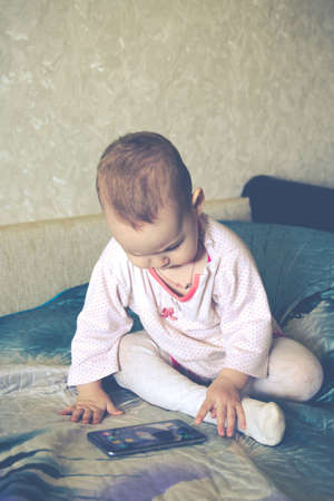 The baby is playing with a smartphoneの写真素材
