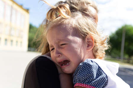 Mom soothes baby. The baby is cryingの写真素材