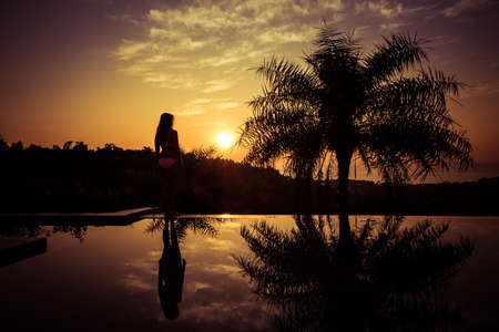 Portrait of a young woman standing against a gorgeous sunsetの写真素材