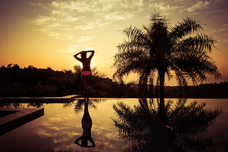 Portrait of a young woman standing against a gorgeous sunsetの写真素材