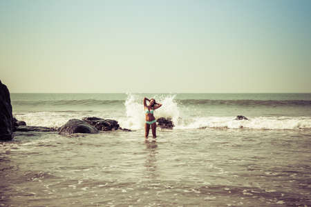 Portrait of a young woman on the background of waves and stonesの写真素材