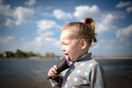 Child eats ice cream in a black waffle coneの写真素材