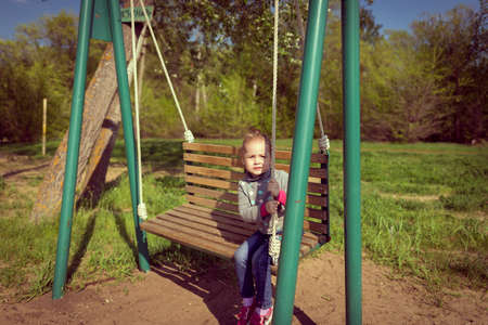 Child swinging a swing. child sitting on a swingの写真素材