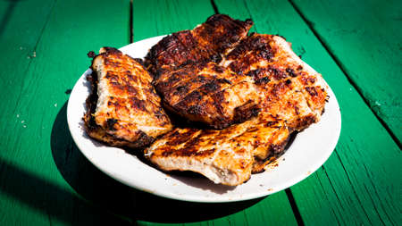 fried meat steaks on a plate on a wooden tableの写真素材