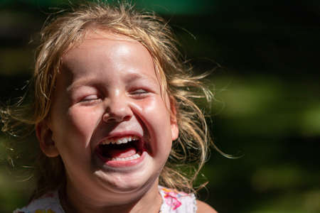 the child is crying and laughing, the child is hystericalの写真素材