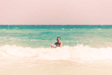 Mom and daughter swim together on the waves, mom teaches daughter to swimの写真素材
