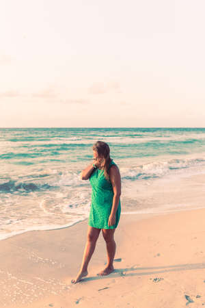 Girl walks along the beach in a dressの写真素材