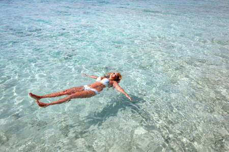 Girl swims in crystal clear and transparent water