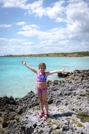 child posing against the background of the sea and stonesの写真素材