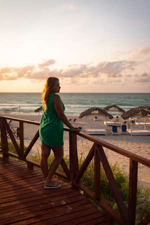 The girl looks at the sea at sunsetの写真素材