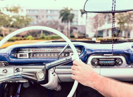 convertible, dashboard of a retro car. Hand on the wheel