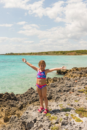 child posing against the background of the sea and stonesの写真素材