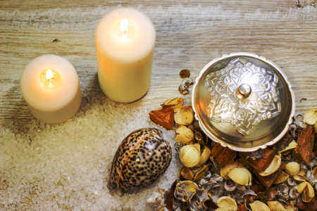 still life with sea salt two candles shells pebbles and flower flavor on a wooden backgroundの写真素材
