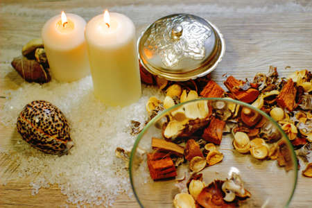 still life with sea salt two candles shells pebbles and flower flavor on a wooden backgroundの写真素材