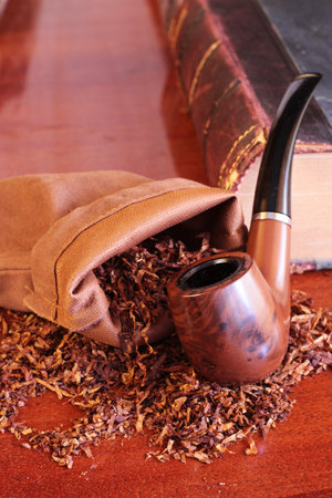 still life with tobacco pipe old book and loose tobacco on a wooden backgroundの写真素材