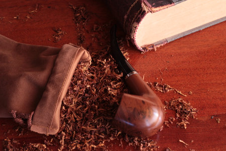 still life with tobacco pipe old book and loose tobacco on a wooden backgroundの写真素材