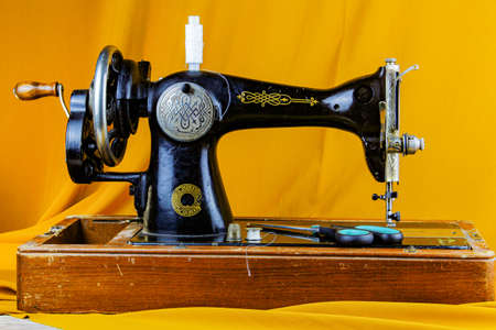 old sewing machine with threads thimble and other on a table