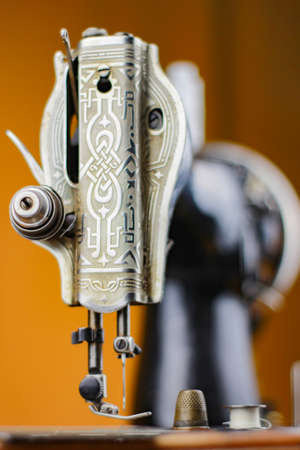 old sewing machine with threads thimble and other on a table