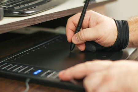 artists hands drawing on a graphics tablet