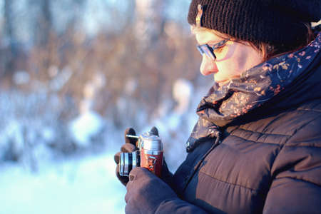 young lady with old camera shooting winter landscape