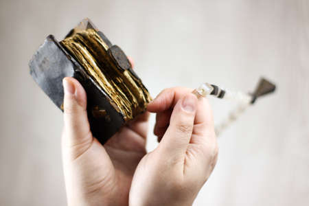old battered prayer book and rosary in hand