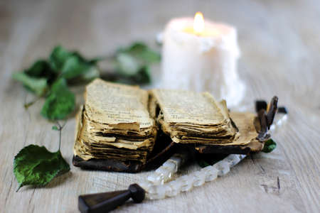 old prayer book rosary and candle on a table