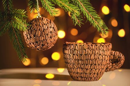 Festive background for New Year greetings in coffee colors. Coffee mood in a New Year's card. New Year holiday coffee background. Cup of coffee and new year lights on the tree. の写真素材