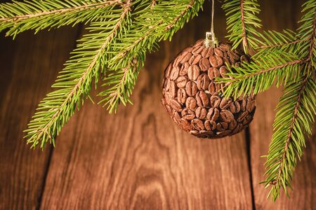 Coffee and New Year holidays.Coffee beans Christmas tree toy. New Year tree with Christmas tree toy in coffee beans with holiday lights in the background. Brown festive Christmas coffee background with bokeh in the background.の写真素材