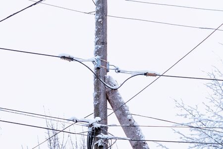 Old electrical technology.Heavy snow on electrical wires.Winter. Dangerous electricity wires.  Frozen electric wires in the city. Uncleaned snow on wires. Old electrical cables. の写真素材