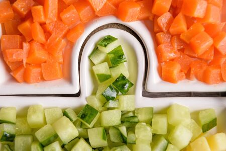 Delicious fresh pieces of vegetables from carrot and cucumber, close-up.の写真素材