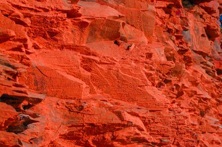 Surface with a texture of red stone. Designer background for interiors. Stone surface of a red rock.の写真素材