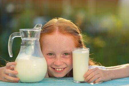 Girl holds glass with fresh milk.の写真素材