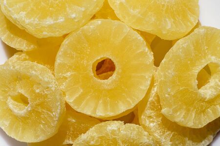 Dried pineapple candy rings, in powdered sugar, close-up.の写真素材