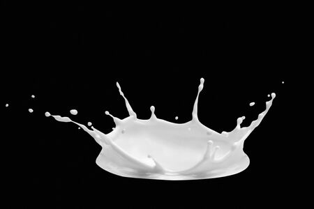 Splash of milk in the form of milk crown. Milk pouring splash isolated on black background.の写真素材
