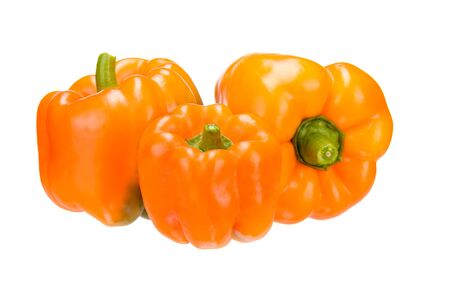 Fresh vegetable. Three bulgarian peppers, orange variety, close-up on a white background.の写真素材