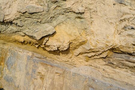 Surface of the rock with a granite stone texture. Designer background for interiors. Stone surface of a yellow texture close-up.の写真素材