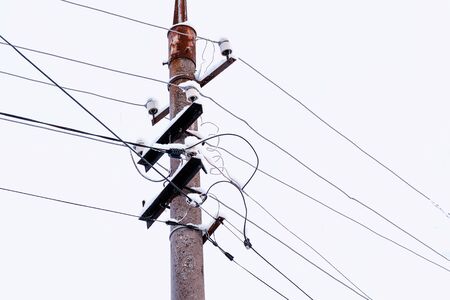High-voltage wires on a pole close-up in the snow.の写真素材