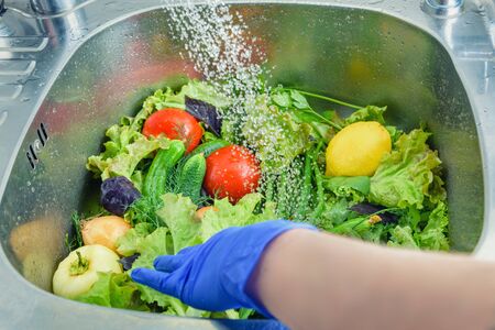 Wash vegetables before eating. Photo of vegetables in the sink. Delicious fresh vegetables close-up.の写真素材
