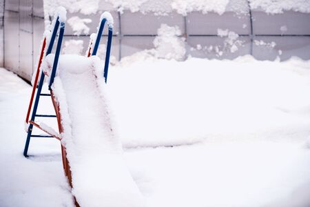 Children's slide is covered with snow. Concept of winter and severe weather.Snowy Winter.の写真素材