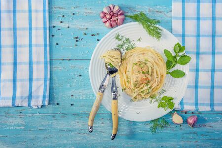 Beautifully-servered, turquoise wooden table, on which there is a plate with Italian pasta with chicken and white sauce, napkins with a spoon and fork lie on the table.
の写真素材