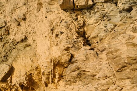 Surface of the rock with a granite stone texture. Designer background for interiors. Stone surface of a yellow texture close-up.の写真素材
