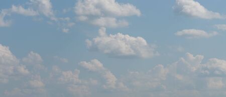 The blue sky with white clouds, in the rays of sunlight.