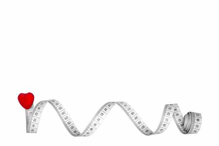 Concept of healthy lifestyle. Flexible meter and red heart closeup isolate on white background.Sports and pulse control.の写真素材