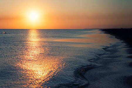  Sunset on the beach. Bright sunset against the sky and the sea. Beautiful sunset over a calm ocean or sea.の写真素材