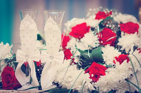 Beautiful table for the newlyweds. Wedding bridal bouquet on a table with two glasses of champagne.の写真素材
