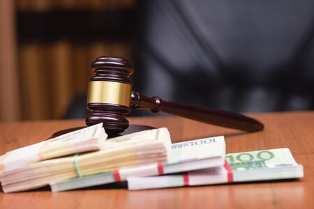 Corrupt court.Trial of money scammers. Judge's gavel and bundles of money on the judge's table.