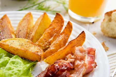 Delicious golden crusty crust of French fries in a fast food cafe. Unhealthy, but tasty unhealthy food. Fried potato sticks with bacon and egg.の写真素材