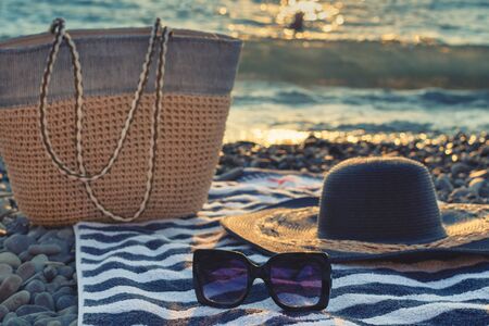 Hat and sunglasses on a pebble by the sea. Weekend on the beach by the sea.の写真素材
